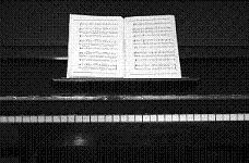 black upright piano with sheet music black upright piano with sheet music